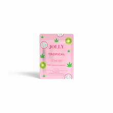 A pink Jolly Cannabis Tropical Gummies packet contains Arizona-made hemp gummies, with green hemp leaves, tropical fruit art, and white text showing 15mg THC and 15mg CBD per gummy; there are 2 gummies inside.