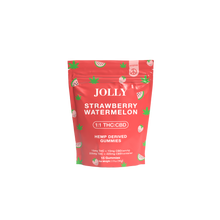 A red resealable pouch of Jolly Cannabis Strawberry Watermelon Gummies features fruit slice art and green hemp leaves, clearly labeled 1:1 15mg THC/15mg CBD per gummy. Each Arizona-made bag contains 15 hemp-derived gummies.