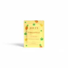 A bright yellow Jolly Cannabis packet labeled Pineapple Gummies 15mg THC, 15mg CBD features cartoon pineapples and cannabis leaves. The Arizona-made, hemp-derived gummies package displays dosage info on a white background with a subtle shadow.